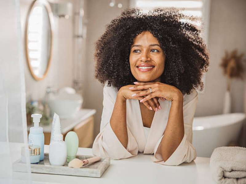 A woman taking care of her skin, applying skincare products as part of a self-care routine for healthy, glowing skin.