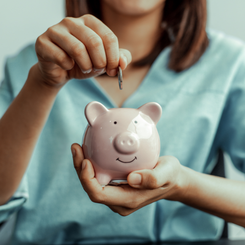 Woman budgeting at home with notebook and calculator, planning how to save $10,000 in a year on a tight budget.