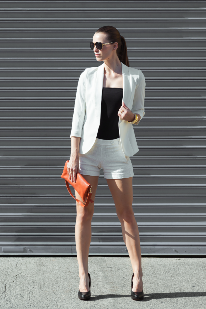 Woman selecting clothes from a closet organized by color and category to simplify daily outfit choices.