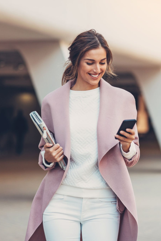 Fashionable woman laying out a pre-planned outfit with blazer, jeans, and heels for a quick morning routine.
