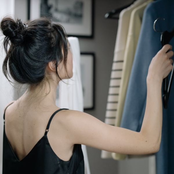 Female looking in her closet for her daily outfit.