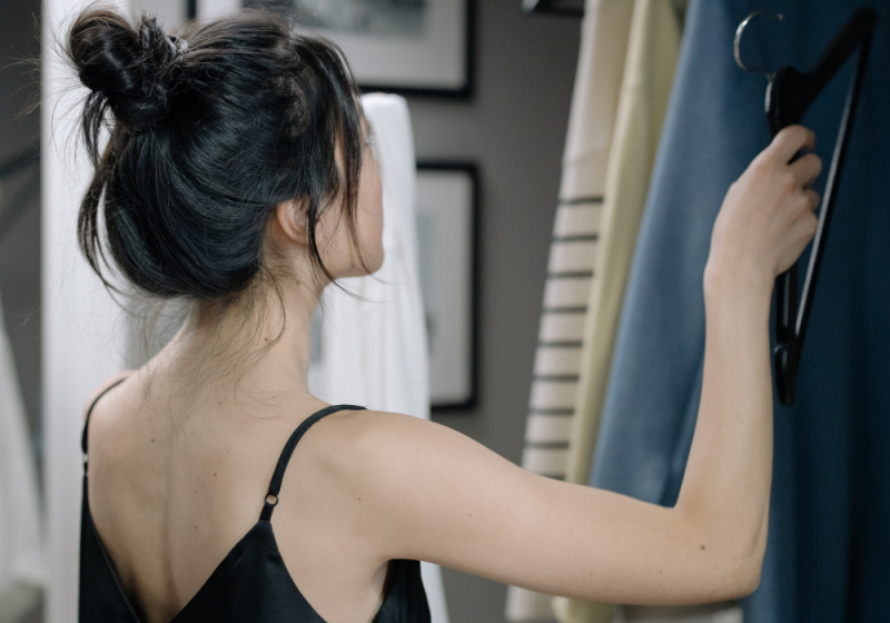 Female looking in her closet for her daily outfit.