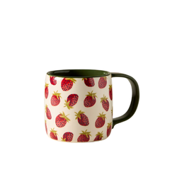 Ceramic strawberry-themed mug with a vibrant red and green design, displayed on a clean surface, highlighting its playful and whimsical style for enjoying hot beverages.