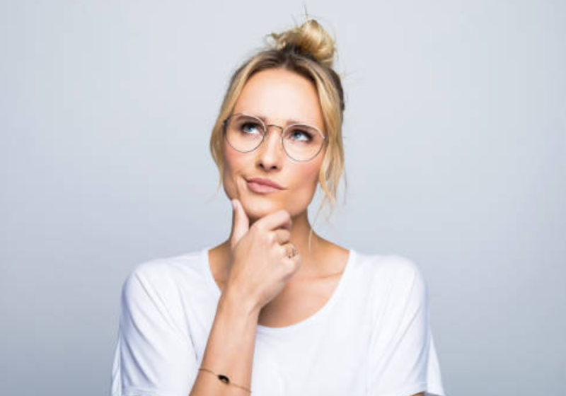 Confident professional woman smiling while working at a desk, symbolizing the power of setting boundaries and saying no for career success.