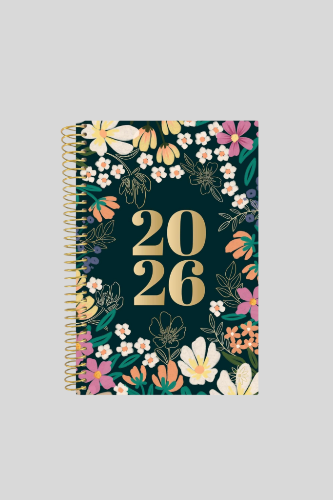 Bloom Daily Planner 2026 with floral cover design and gold spiral binding.