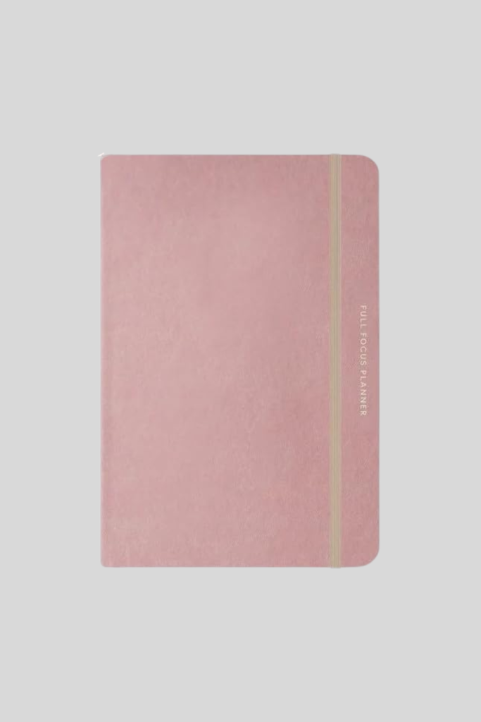 Full Focus Planner open on a desk, showing daily and weekly goal-tracking pages for productivity and time management.