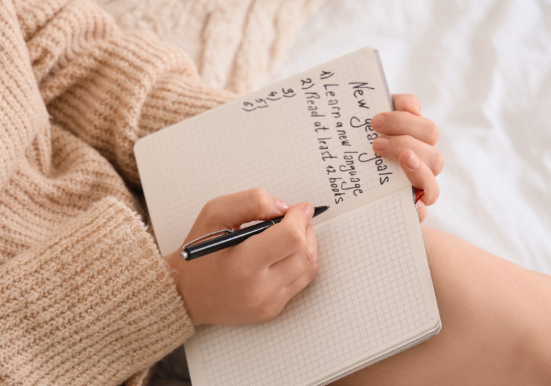 Woman documenting her yearly goals to achieve progress and success.
