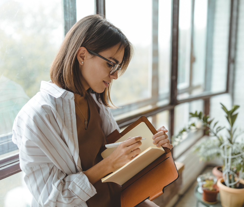 Woman using a simple planning system in a notebook to organize her 2026 goals.