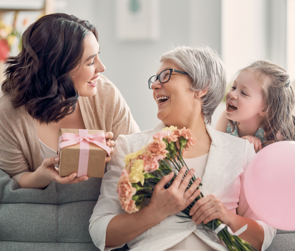 Grandmother, mother and daughter smiling and enjoying mother's day with each other.