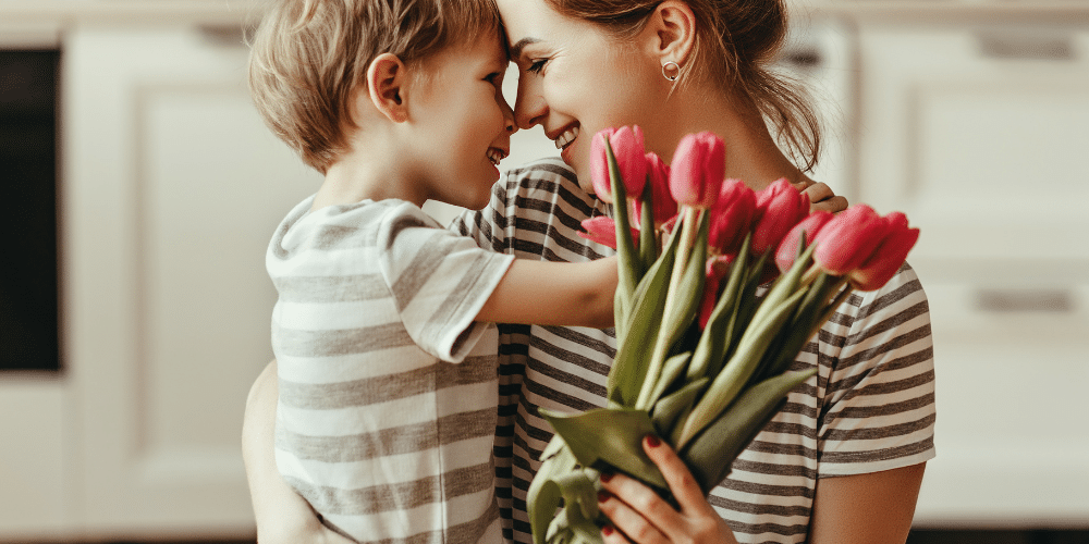 Mother and child celebrating mother's day with flowers.