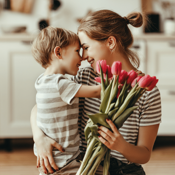 Mother and child celebrating mother's day with flowers.