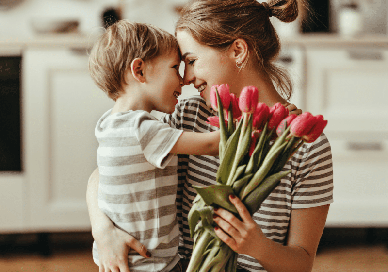Mother and child celebrating mother's day with flowers.